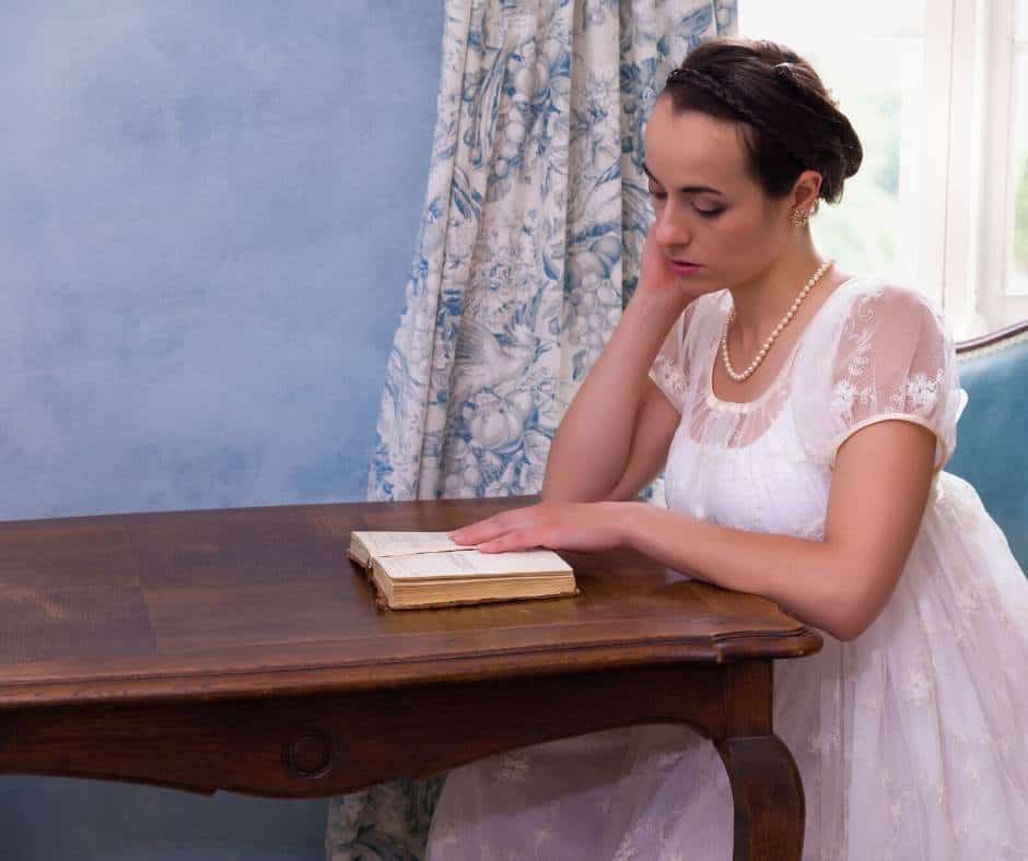 Woman in regency dress reading at a table; Jane Austen experience